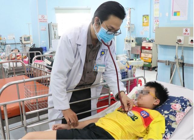 TS.BS Nguyễn Minh Tuấn - Trưởng khoa Sốt xuất huyết - Huyết học Bệnh viện Nhi đồng 1 (TP.HCM), thăm khám bệnh nhân bị sốt xuất huyết. Ảnh: Xuân Mai